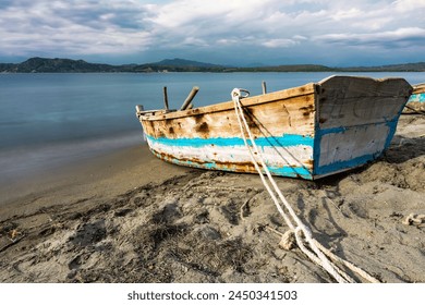 Dramatic long exposure of a abandoned weathered old fishing boat on the coast of the Caribbean sea in the Dominican Republic.