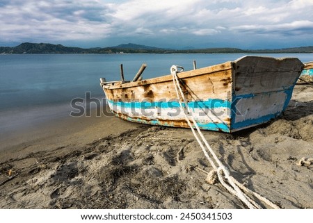 Dramatic long exposure of a abandoned weathered old fishing boat on the coast of the Caribbean sea in the Dominican Republic.