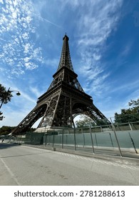 Dramatic low angle view of Eiffel Tower in Paris against blue sky, iconic iron architecture and famous French travel landmark