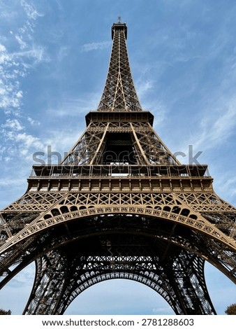 Dramatic low angle view of Eiffel Tower in Paris against blue sky, iconic iron architecture and famous French travel landmark