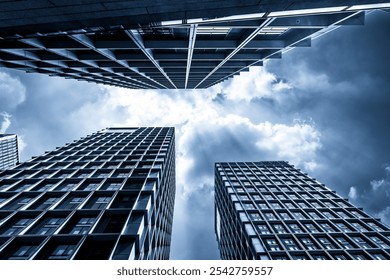 Dramatic Low Angle View of Modern Skyscrapers Under Cloudy Sky  