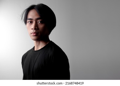 Dramatic Low Light Portrait Of Handsome Asian Man Looking Up. Side Light Effect