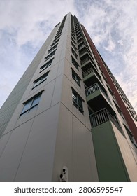 A dramatic low-angle perspective looking up at the towering, modern facades of residential buildings, showcasing the geometric contrast between the warm-toned and cool-toned architecture against the sky.
​A symmetrical, full-frame shot of a towering high-rise apartment building, highlighting the repetitive pattern of balconies and windows reaching toward the sky.
​A wide-angle, low-perspective view capturing multiple high-rise structures converging toward the center of the frame, emphasizing the density and scale of modern urban living.