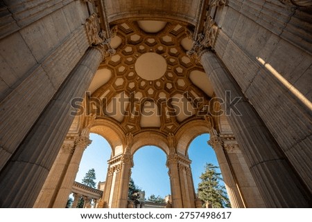 A dramatic low-angle perspective showcases the towering Greco-Roman columns and intricate rotunda of the Palace of Fine Arts against a brilliant blue San Francisco sky.