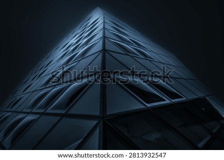 Dramatic low-angle view of the crystalline glass and steel diamond-lattice facade of the Prada Aoyama flagship store glowing against a dark night sky.