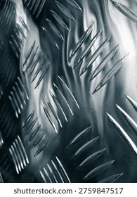 Dramatic macro view of reflective metallic diamond tread plate with sharp highlights
