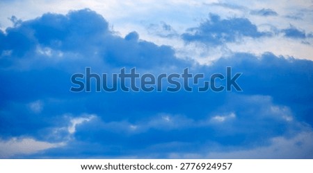 Dramatic meteorological scenery capturing heavy dark blue and grey cloud masses gathering ominously over an unseen vast distant horizon.