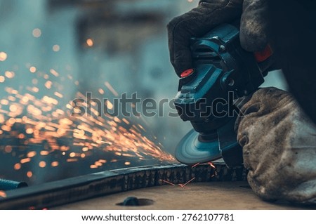 Dramatic moment of metal grinding with angle grinder, producing stream of glowing sparks. Scene captures motion, energy, and intensity of industrial work in workshop environment.