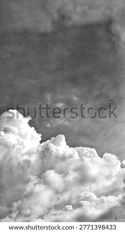 Dramatic monochrome cumulus clouds against a dark, textured sky. This moody, vintage-style atmosphere features high contrast and grainy artistic details, perfect for dramatic backgrounds and fine art.