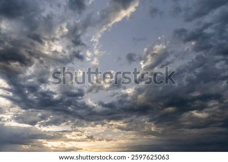 A dramatic and moody sky filled with dark, swirling clouds, evoking a sense of mystery and atmosphere