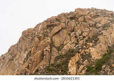 Dramatic Morro Rock Volcanic Plug Shrouded in Cloudy Weather and Coastal Fog, Morro Bay, California
