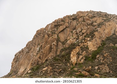 Dramatic Morro Rock Volcanic Plug Shrouded in Cloudy Weather and Coastal Fog, Morro Bay, California
