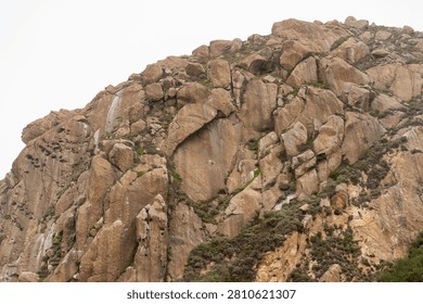 Dramatic Morro Rock Volcanic Plug Shrouded in Cloudy Weather and Coastal Fog, Morro Bay, California