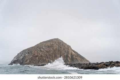 Dramatic Morro Rock Volcanic Plug Shrouded in Cloudy Weather and Coastal Fog, Morro Bay, California