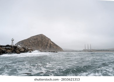 Dramatic Morro Rock Volcanic Plug Shrouded in Cloudy Weather and Coastal Fog, Morro Bay, California
