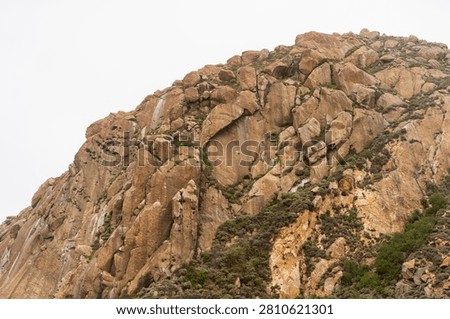 Dramatic Morro Rock Volcanic Plug Shrouded in Cloudy Weather and Coastal Fog, Morro Bay, California
