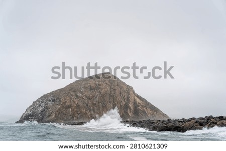 Dramatic Morro Rock Volcanic Plug Shrouded in Cloudy Weather and Coastal Fog, Morro Bay, California