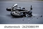 A dramatic motorcycle accident scene, showcasing a fallen bike amidst scattered glass and debris on the road, highlighting the dangers of road safety.
