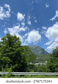 Dramatic mountain landscape covered in dense, moody clouds, creating a powerful and atmospheric scene. The mountain peaks emerge through the mist, while heavy clouds roll across the sky, adding depth, mystery, and a sense of raw natural beauty. The composition highlights the contrast between rugged terrain and soft, shifting cloud formations, evoking feelings of awe, solitude, and tranquility in nature.
