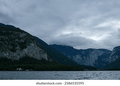 Dramatic Mountain Landscape with Low Clouds over Lake