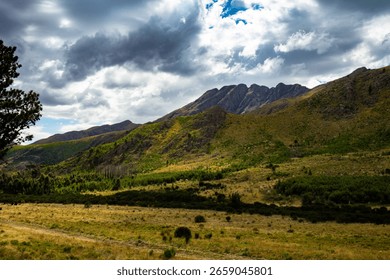 Dramatic Mountain Landscape under Cloudy Sky with Green Valleys and Rugged Peaks. Scenic Highlands.
