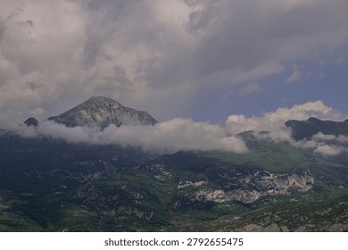 Dramatic mountain peak under a moody cloudy sky in the Maritime Alps.Majestic alpine landscape with rugged cliffs and thick storm clouds at sunset. Scenic view of mountain range in the Alps under dramatic sky.
