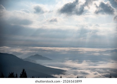 Dramatic Mountain View with Mist and Sunlight Breaking Through Clouds