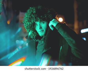 Dramatic Night Retro Wave Portrait Of A Man Wearing Jacket Lit By  Green Neon Light.High Fashion Male Model In Colorful Bright Neon Lights Posing On Black City Background. Art Design Concept.
