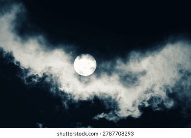 A dramatic night sky featuring a bright full moon partially obscured by dark, moody clouds. Spooky and atmospheric night scene.