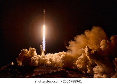 A dramatic night sky illuminated by a fiery rocket launch. Smoke and flames billow from the spacecraft as it ascends into the darkness, leaving a trail of. Elements of this image furnished by NASA - Powered by Shutterstock