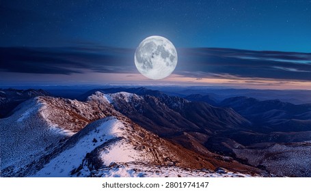 Dramatic Nighttime View of Snowy Mountains Beneath a Radiant Full Moon