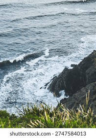 Dramatic ocean waves crash against the rocky cliffs of the rugged coastline