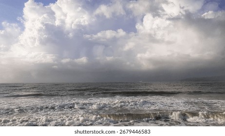 Dramatic ocean waves under cloudy sky, perfect seascape background for travel, nature, and landscape design with stormy sea atmosphere.