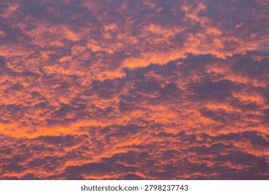 Dramatic orange and pink clouds illuminated by sunset light across the evening sky