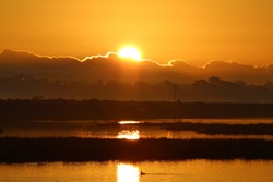 Dramatic Orange Sunrise In The Morning Over Water At Bolsa Chica Ecological Reserve California, USA