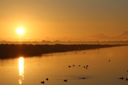 Dramatic Orange Sunrise In The Morning Over Water At Bolsa Chica Ecological Reserve California, USA 
