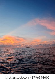 Dramatic Orange Sunset Sky Over Calm Sea Landscape

Vibrant fiery orange clouds on a deep blue sky during sunset over dark ocean water ripples, ideal for background, travel, and nature projects.