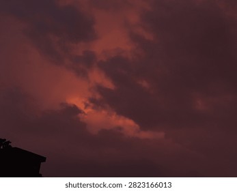 Dramatic Orange Sunset Sky with Rain Clouds During Monsoon