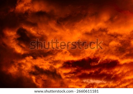 Dramatic, orange-colored cloudy sky with filigree ramifications of individual wispy clouds