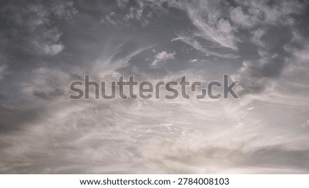 Dramatic overcast sky filled with dark grey and wispy white storm clouds.