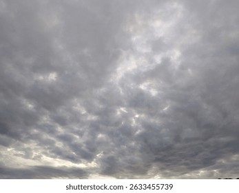 A dramatic overcast sky filled with dense gray clouds during the early evening. Captured with natural light, perfect for weather-themed projects, moody backgrounds, or conceptual designs.