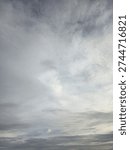 Dramatic overcast sky with soft grey and white clouds. Natural abstract weather background texture.