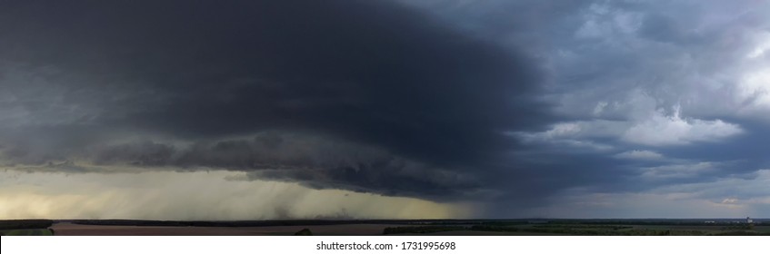 Dramatic Panorama With Dark Storm Clouds. A Thunderstorm That Raises Dust And Pours Heavy Rainfall.