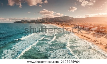 Dramatic panoramic aerial view of iconic Sarti resort town and famous long and empty sandy beach at sunset time with high waves. Vacation on Halkidiki, Greece