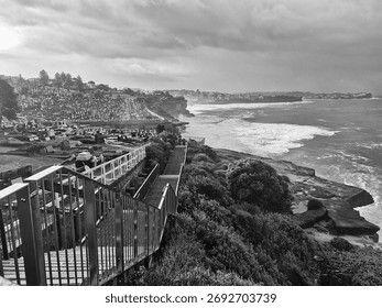 Dramatic panoramic black and white view of a graveyard located on a sweeping coastline by the sea.