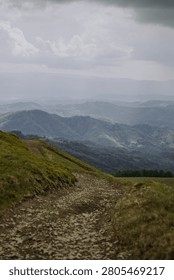 Dramatic panoramic view of Carpathian mountains with layered green hills, forest and valley under stormy sky. Moody landscape capturing the wild and majestic natural beauty of Eastern European nature.