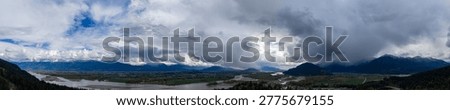 Dramatic panoramic view of river channels, farmland and storm clouds over Harrison Mills in Fraser Valley, British Columbia, Canada