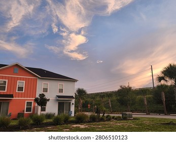  Dramatic pastel clouds sweep across the evening sky above a quiet suburban neighborhood, creating a peaceful sunset scene with soft light and vibrant colors. The unique cloud formations highlight the beauty of nature meeting everyday residential life.

A colorful sunset sky filled with swirling clouds overlooks modern homes and palm trees, capturing the calm atmosphere of a warm evening in a suburban community.

1. Sunset


2. Evening sky


3. Colorful 

4. Dramatic 


5. Cloudscape


6. Pink 

7. Blue 


8. Residential neighborhood


9. Suburb


10. Modern homes


11. House


12. Palm trees


13. Florida



Dramatic Sunset Clouds Over a Modern Suburban Neighborhood
