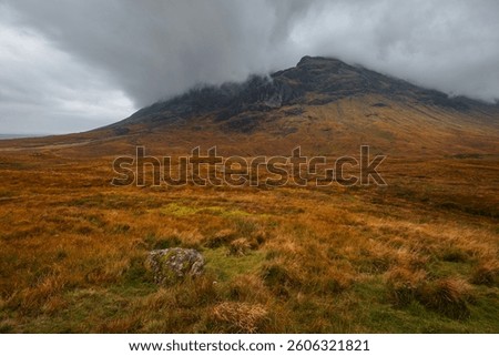 Dramatic peaks and misty valleys define Glen Coe, Scotland’s iconic Highland landscape. Golden light dances on rugged slopes, creating a scene of wild, untamed beauty.