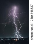 A dramatic photograph capturing powerful lightning strikes illuminating the dark sky. The jagged bolts of electricity contrast against the storm clouds, creating a breathtaking natural spectacle.